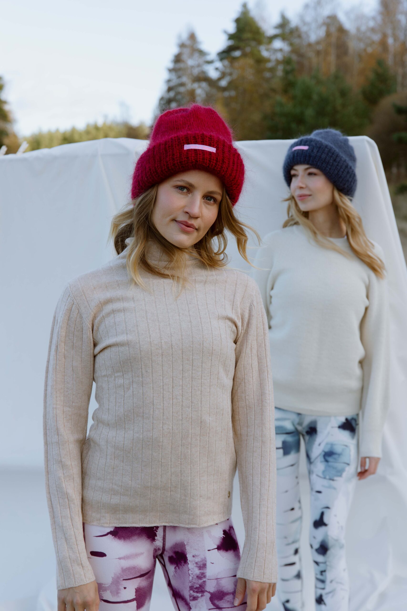 Woman in the foreground wearing Silver birch - Soahki lily pink and purple watercolor print leggings with a beige turtleneck and red beanie